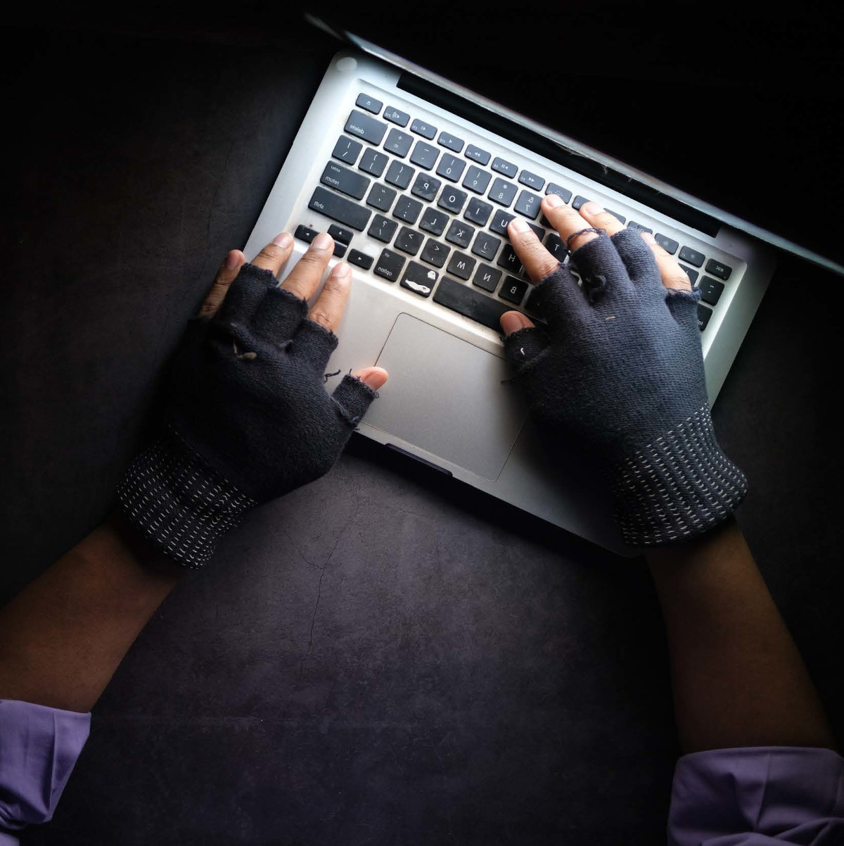 Close Up of Gloved Hands on Computer in the Dark