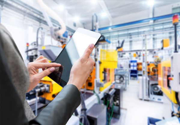 User holding a tablet in a manufacturing facility