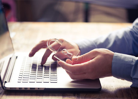 User on the laptop holding a transparent padlock