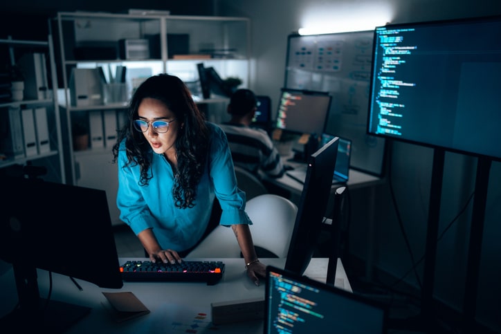 Two computer programmers working together on a computer code at night, Computer operators running system diagnostic tests. IT specialists deploying error checking utilities to fix network issues.
